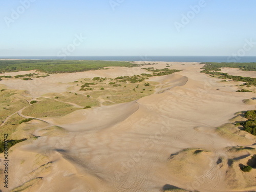 Vista aérea de las dunas cerca del mar, con algo de vegetación, durante el atardecer.  photo