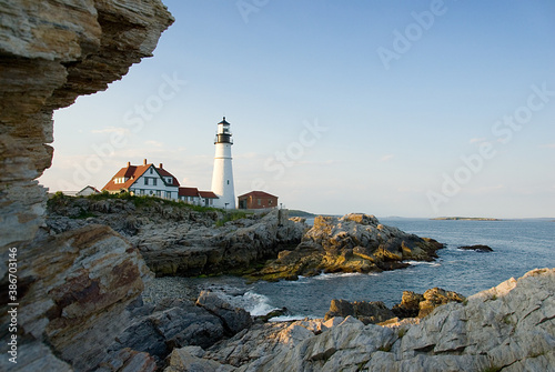Lighthouse on the coast of Maine with rocks at sunset
