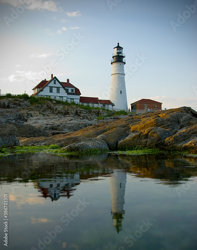 Reflection of a lighthouse on the coast of Maine at sunset during summer