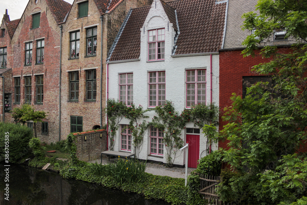 Bruges, Belgium - May 12, 2018: Unique Houses Above A Water Channel Bruges, Belgium - May 12, 2018: Unique Houses Above A Water Channel