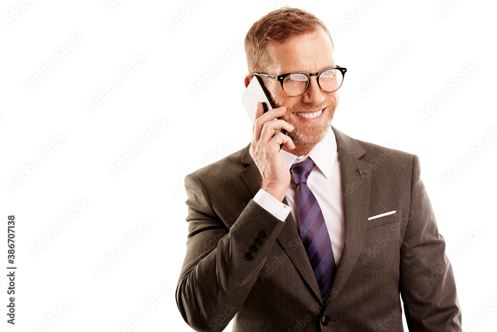 Happy middle aged businessman wearing suit and making call while standing at isolated white bakcground with copy space. Happy middle aged businessman wearing suit and making call while standing at isolated white bakcground with copy space.