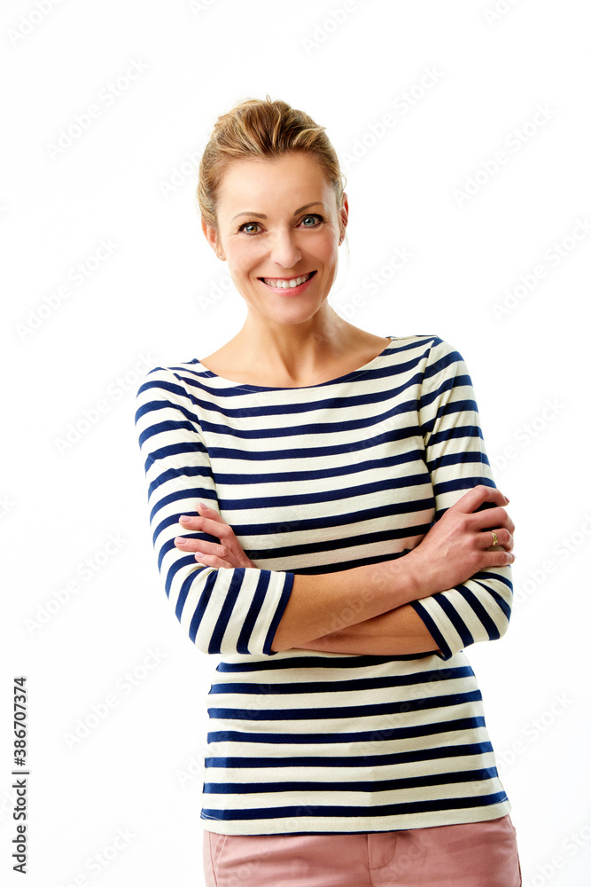 A beautiful mature woman with arms crossed standing at isolated white background while looking at camera and smiling. A beautiful mature woman with arms crossed standing at isolated white background while looking at camera and smiling.