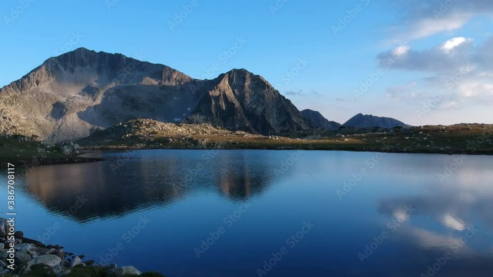 Cinematic going in shot on a lake in a mountain with sky and clouds reflecting in the water, near sunset time Cinematic going in shot on a lake in a mountain with sky and clouds reflecting in the water, near sunset time