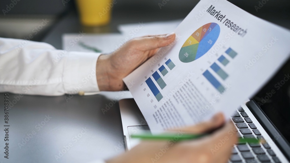 Businessman male hands in white shirt look through graphs and papers in the office. Man no face holding reading papers, graphs with pencil in hand Businessman male hands in white shirt look through graphs and papers in the office. Man no face holding reading papers, graphs with pencil in hand