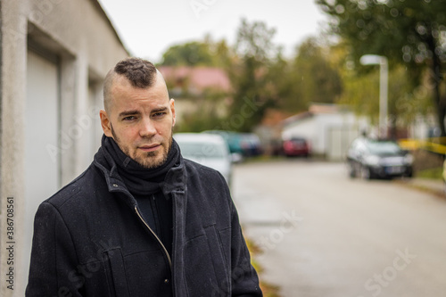 A man stands in front of garages in a small city in Hungary