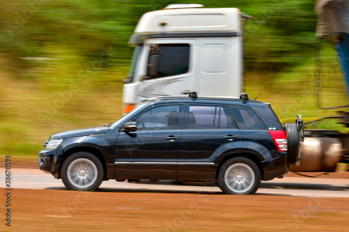 Quadro su tela SUV overtaking truck at speed on highway