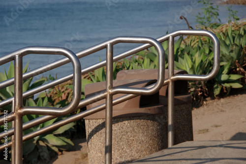Fototapeta Naklejka Na Ścianę i Meble -  Three stainless steel handrails at stairs to an ocean beach