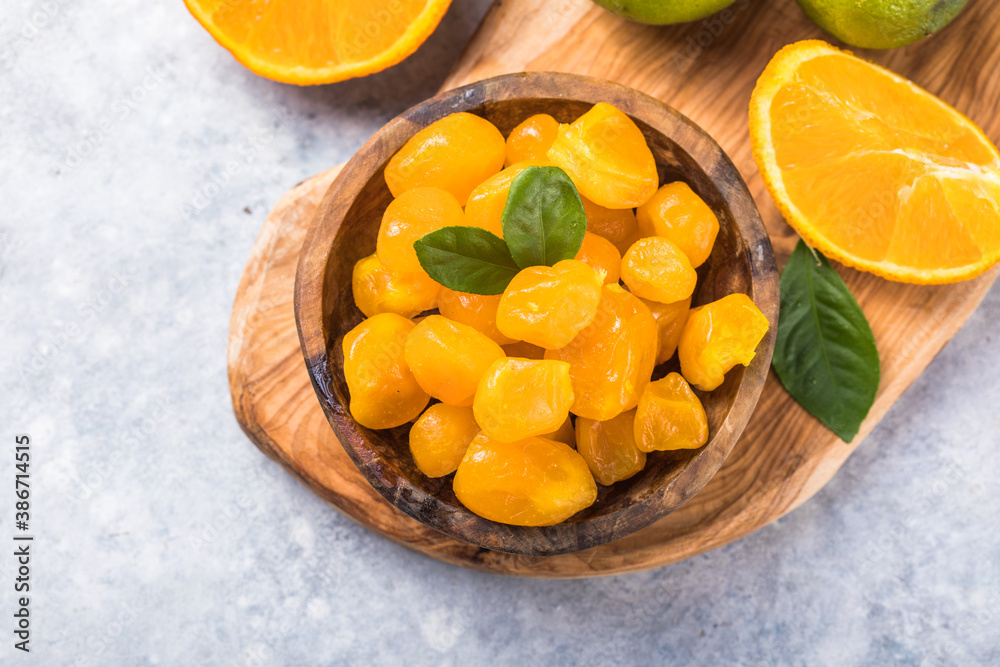 Сandied fruit, dried kumquat with orange flavor in bowl on stone table background. Сandied fruit, dried kumquat with orange flavor in bowl on stone table background.