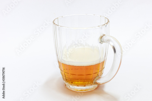 glass of beer half filled with beer on white background