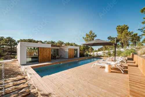 Modern house with garden swimming pool and wooden deck
