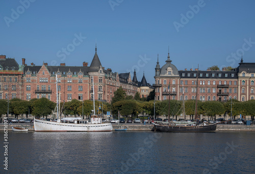 Photography Water view with old wood boats and houses over the district Östermalm an autumn