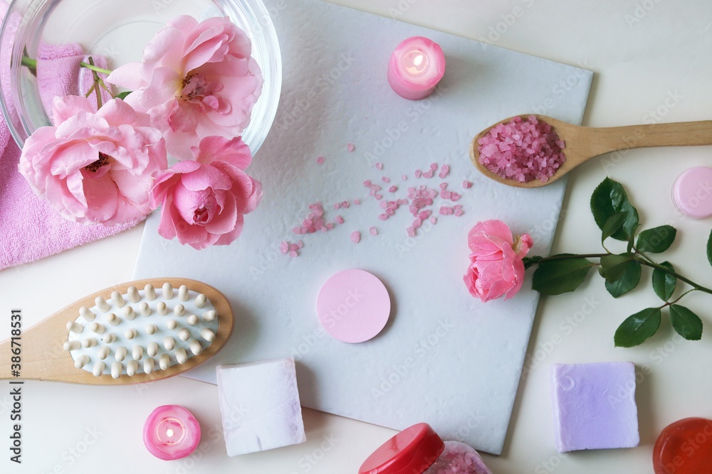 Fresh pink roses, water, petals, candles on a light background, body care products, natural home cosmetics, healthy lifestyle, alternative medicine Fresh pink roses, water, petals, candles on a light background, body care products, natural home cosmetics, healthy lifestyle, alternative medicine