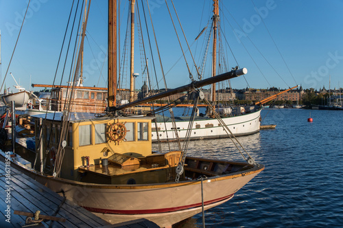 Sail boats at a quay an early sunny morning in autumn in Stockholm harbor at the island Skeppsholmen
