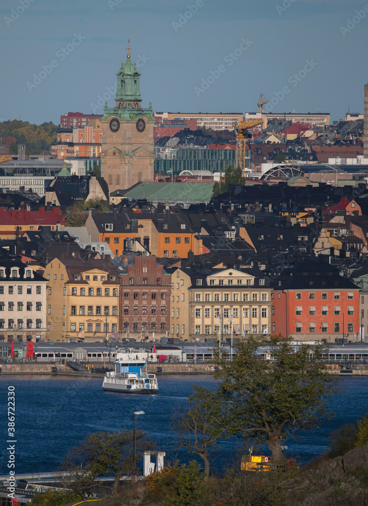 Obraz premium Commuter boat arriving to the quay of the old town Gamla Stan a sunny autumn day