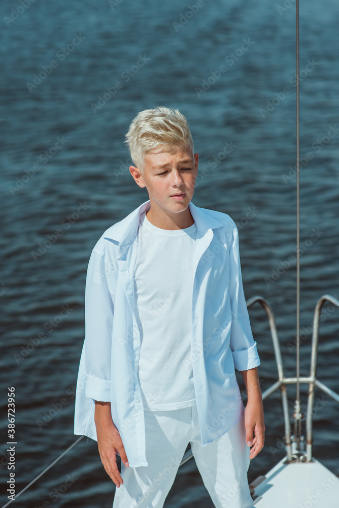 Fototapeta premium handsome Caucasian boy singing on the yacht 