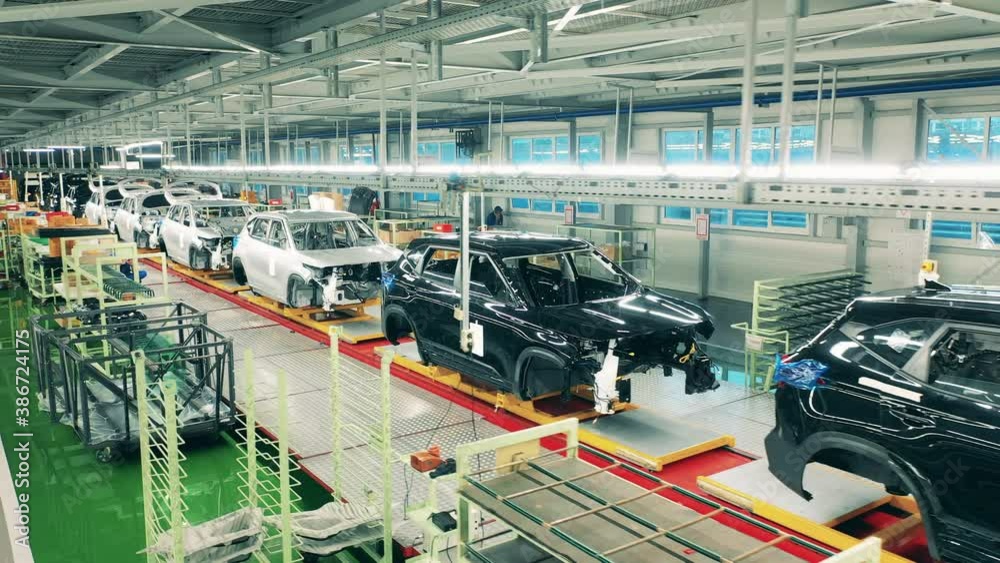 Automobile, car factory conveyor. Factory premises with multiple unfinished automobiles