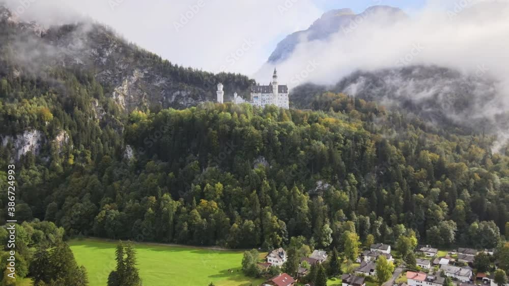 A panning shot of Neuschwanstein Castle in the fog