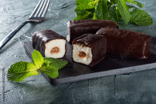 Glazed cheese with condensed milk on a Board with mint. Cheese on a green background with mint.