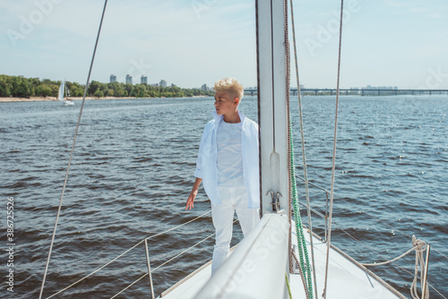 handsome Caucasian boy singing on the yacht © k8most