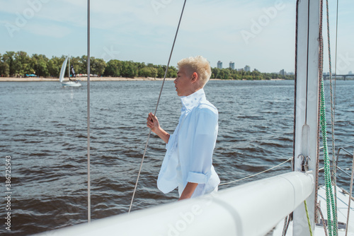 handsome Caucasian boy singing on the yacht