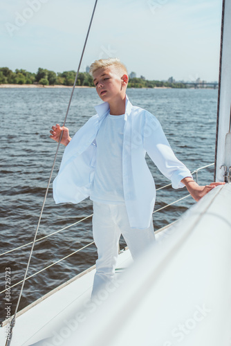 handsome Caucasian boy singing on the yacht © k8most