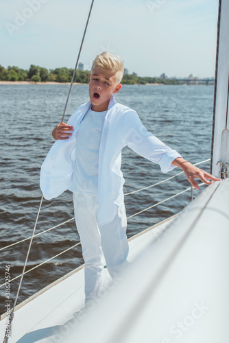 handsome Caucasian boy singing on the yacht