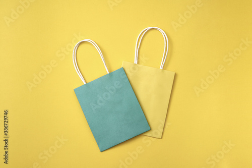 Yellow and blue paper gift bags on a yellow background. Copy space, flat lay, layout, top view