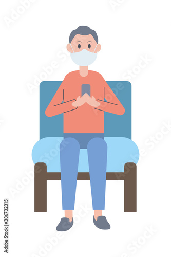 young man wearing face mask using smartphone seated in sofa