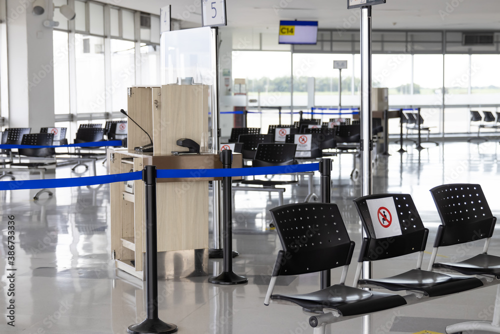 Empty waiting room at an airport during COVID-19 pandemic with social distancing signs on chairs