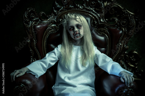 Obraz na plátně evil child sitting in armchair
