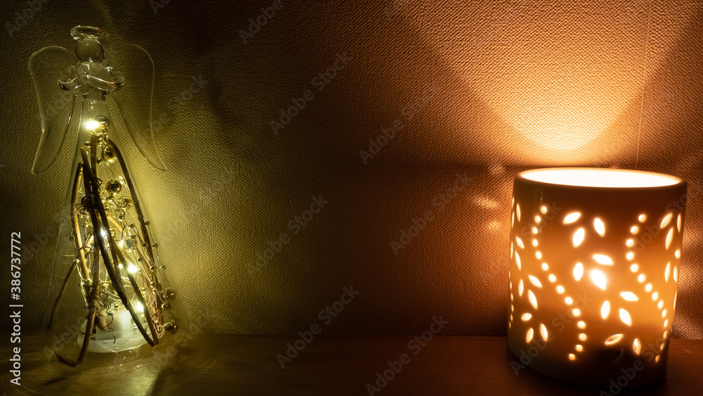 Cozy wallpaper on the background of a candle and a glass figure. Home furnishings.