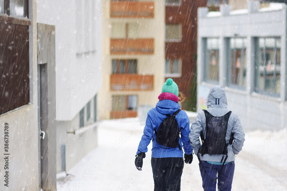 Tourists walking on street of mountain resort town in Switzerland, Europe. Winter vacation. Ski resort. Tourists walking on street of mountain resort town in Switzerland, Europe. Winter vacation. Ski resort.