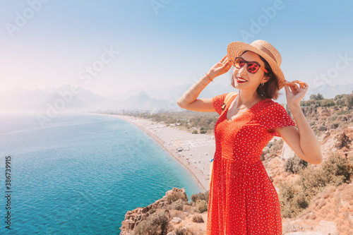Happy female tourist looking from the height of the observation viewpoint overlooking Konyaalti beach in Antalya. Tourism and lifestyle in Turkey