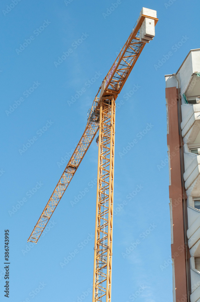 yellow building tower crane against the sky yellow building tower crane against the sky
