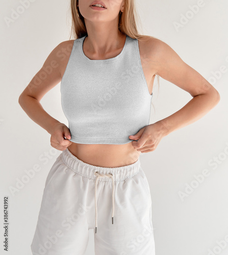 girl wears white crop top and white shorts. studio shooting of young woman in casual street wear