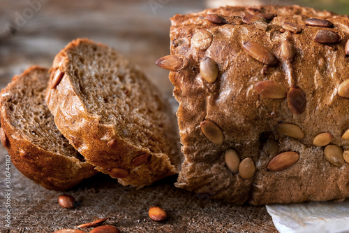 A loaf of bread on paper lies on a wooden table.