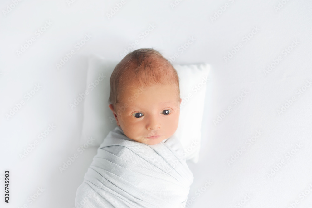 Portrait of a surprised newborn baby. Baby kid looking up to camera. Good morning!

