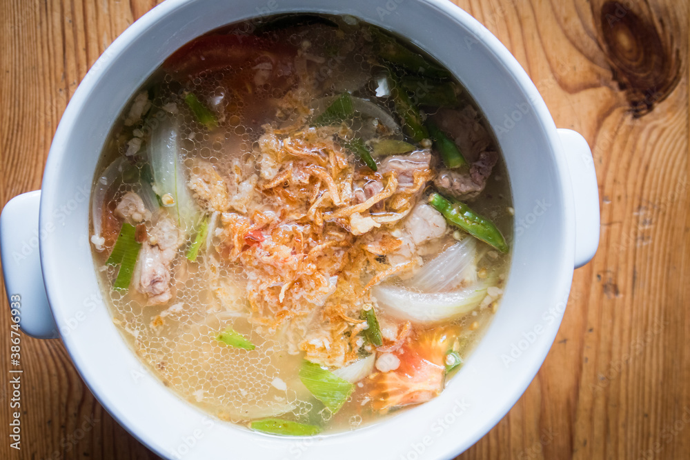Thai beef spicy soup with onion in a bowl. Asian street food Thai beef spicy soup with onion in a bowl. Asian street food