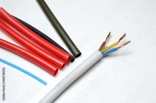 heat shrink tubing and a three-core stripped wire on a white background. photo