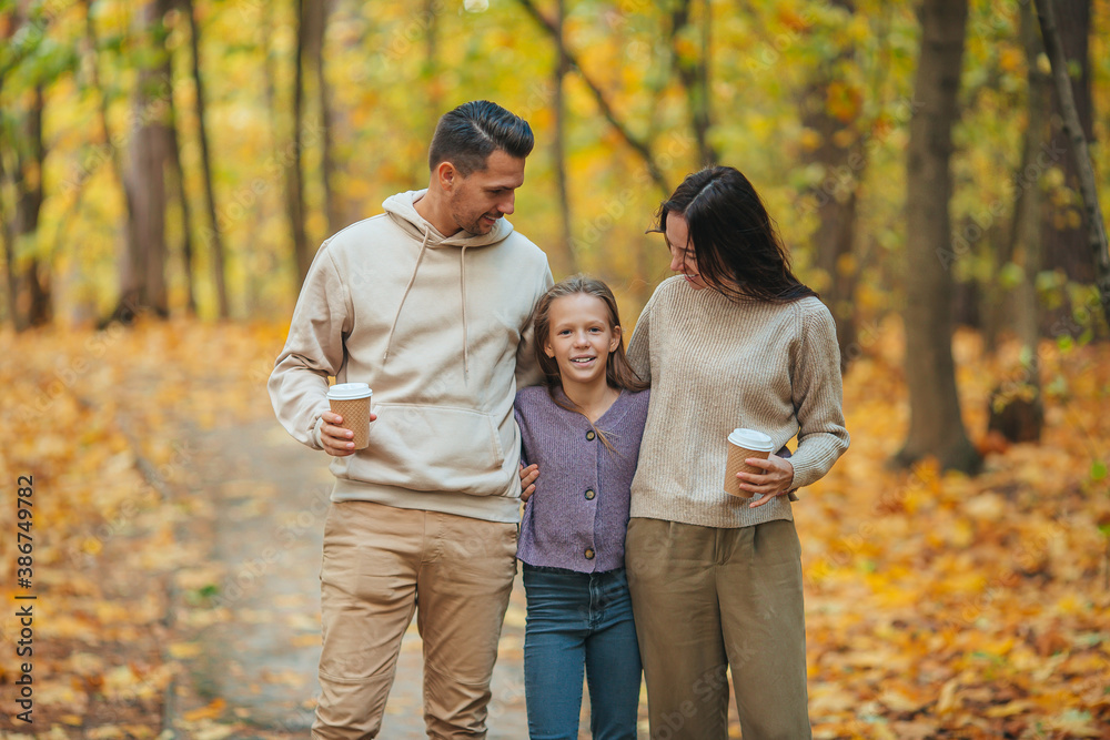 Portrait of happy family of three in autumn day