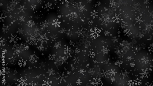 Christmas background of snowflakes of different shapes, sizes and transparency in gray and black colors