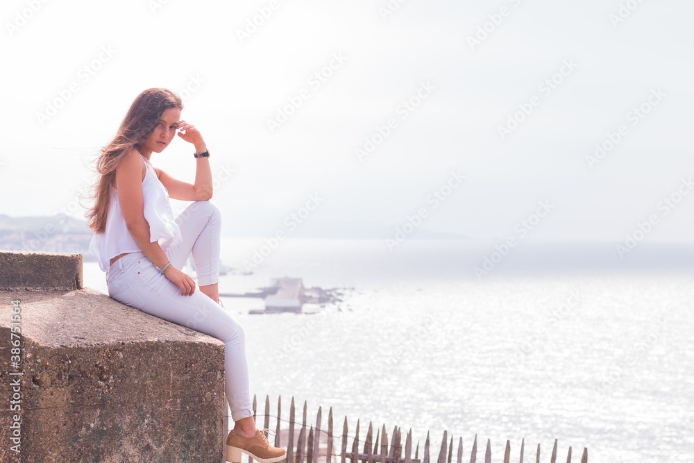 Young caucasian girl with white shirt and jeans posing in a park at Saint Jean de Luz; Basque Country. Young caucasian girl with white shirt and jeans posing in a park at Saint Jean de Luz; Basque Country.