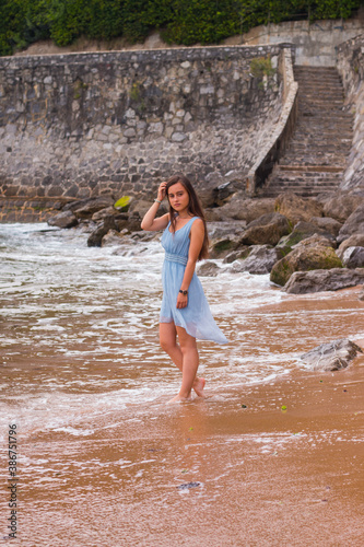 Young girl with a turquoise dress walking through the beach of Saint Jean de Luz  Basque Country. © Jorge Argazkiak