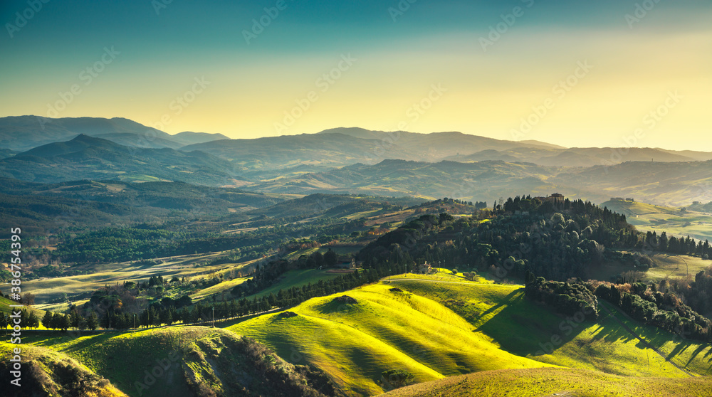 Fototapeta premium Volterra winter panorama, rolling hills and green fields on sunset. Tuscany, Italy