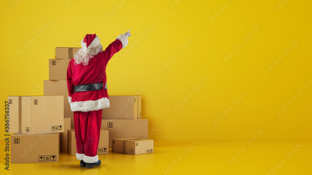 Santa Claus in front of cardboard boxes that indicates something in the wall - obrazy, fototapety, plakaty 