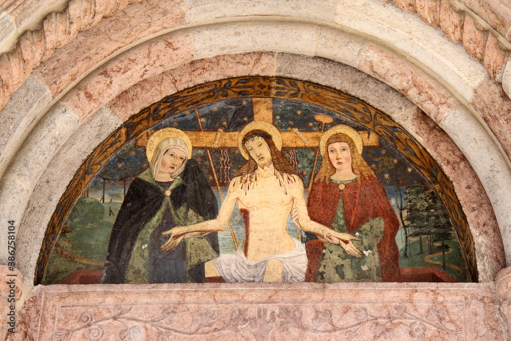 Cristo morto tra Maria e San Giovanni; lunetta del portale della chiesa della Natività di Maria a Pellizzano (Trentino)