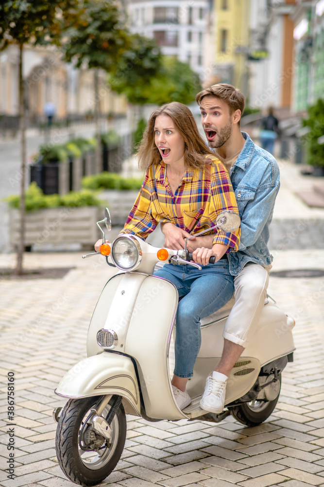 Man teaching a woman to ride a scooter Man teaching a woman to ride a scooter