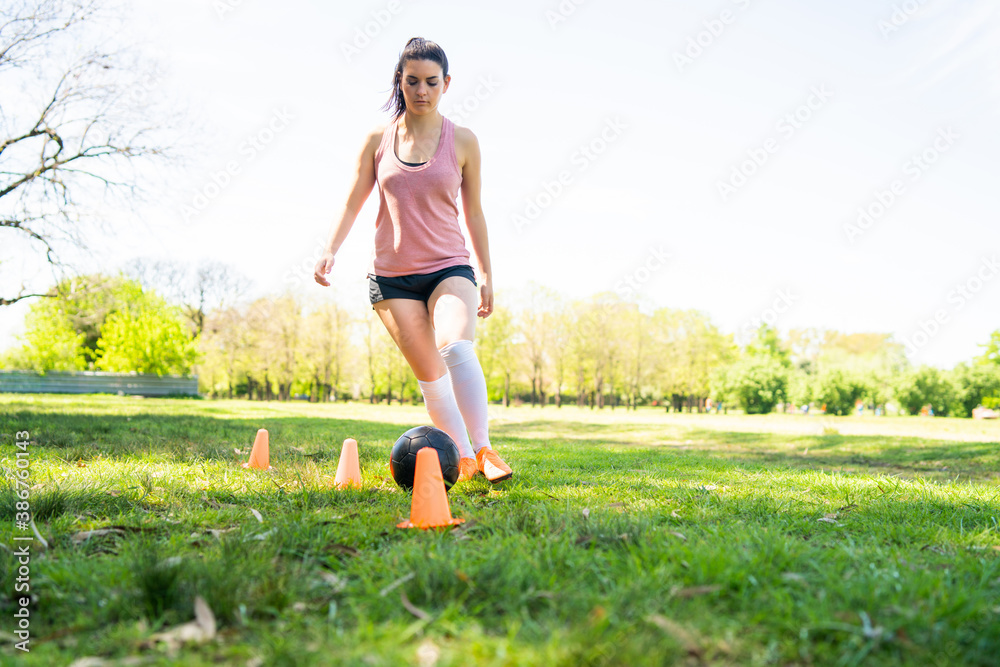 Young female soccer player practicing on field. Young female soccer player practicing on field.