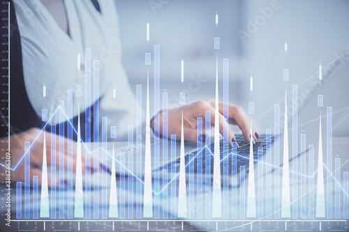 Double exposure of businesswoman hands typing on computer and forex graph hologram drawing. Financial analysis concept.