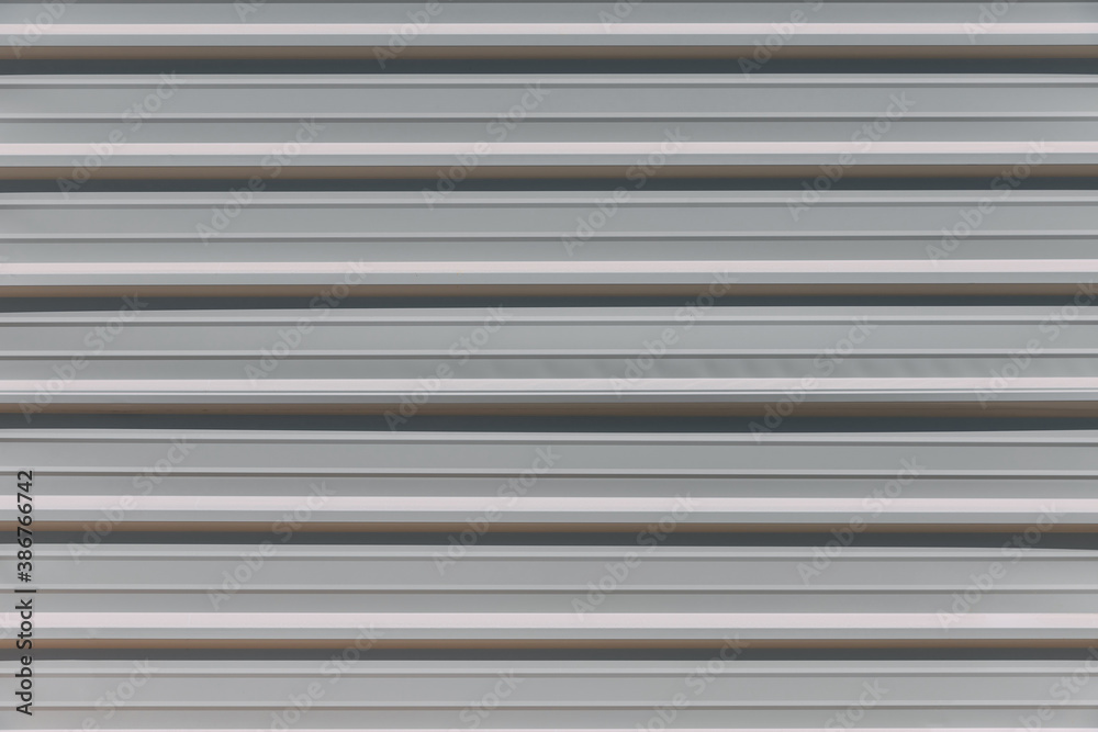 Close-up view of light-colored construction site fence with stripes on a city street. Fence enclosing the construction site. Forbidden entry. Stripes wall pattern Close-up view of light-colored construction site fence with stripes on a city street. Fence enclosing the construction site. Forbidden entry. Stripes wall pattern